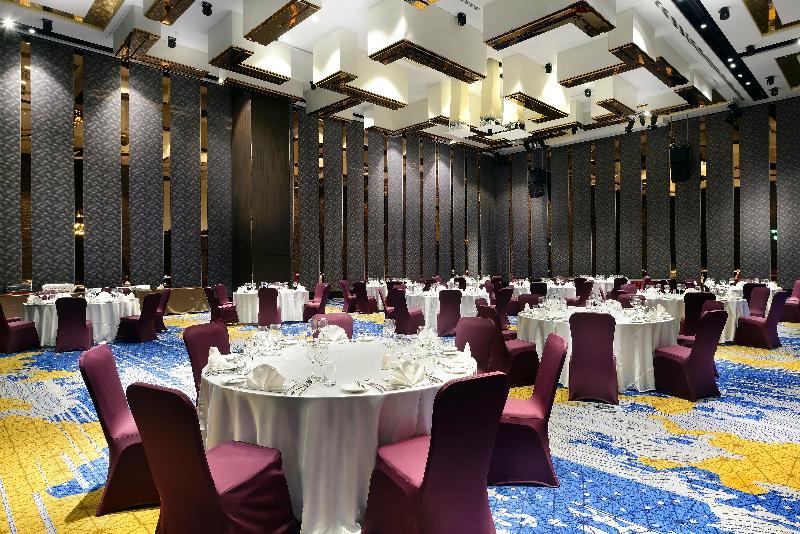 臺北 板桥凯撒大饭店酒店 外观 照片 The photo shows a spacious banquet hall or event space. The room features several round tables, each covered with white tablecloths, set up with place settings. The chairs around the tables are covered in deep burgundy fabric. The flooring has a colo