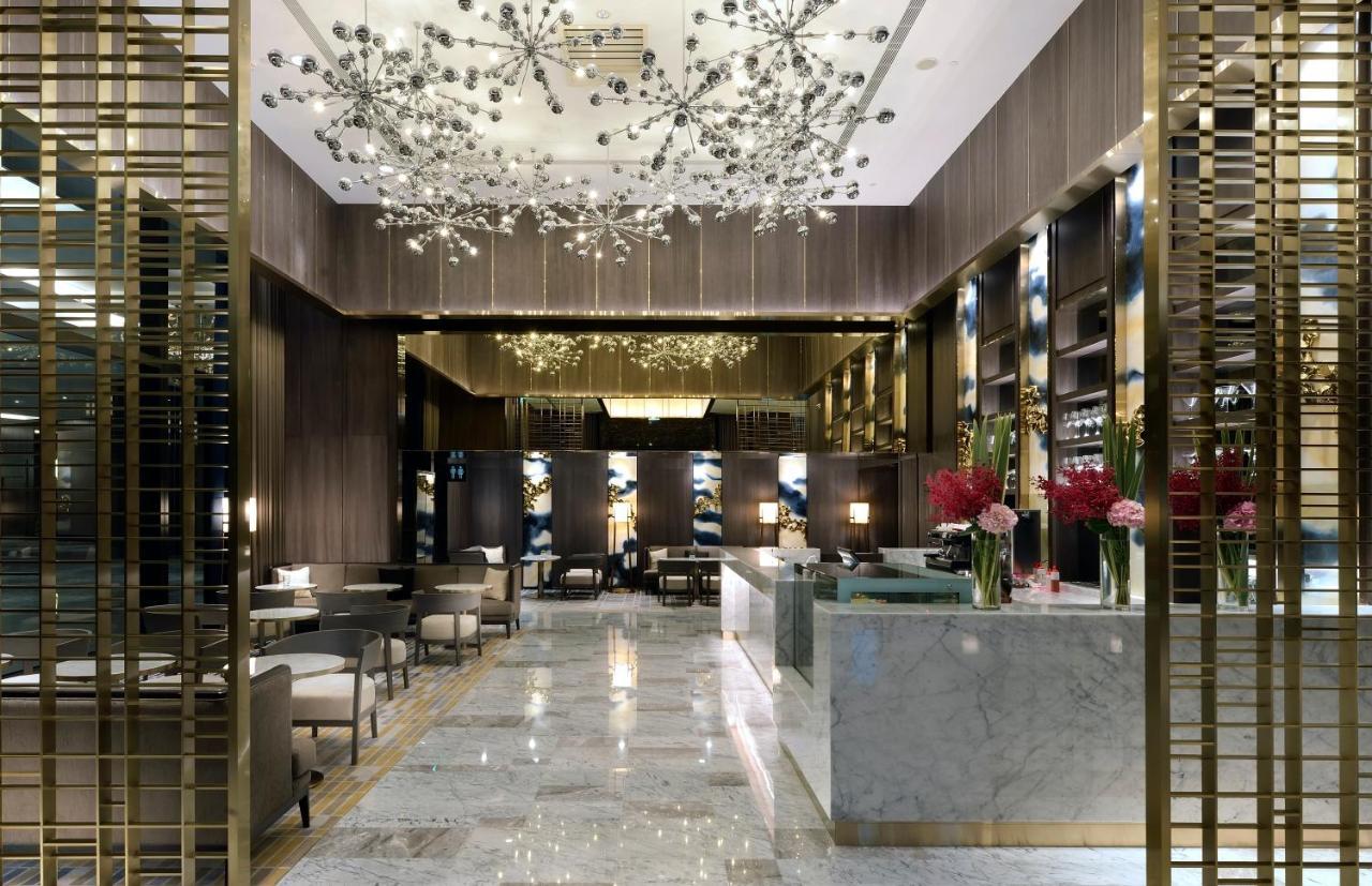 臺北 板桥凯撒大饭店酒店 外观 照片 The photo shows an elegant and modern hotel lobby. The space features luxurious decor with marble flooring and a tasteful color palette. The ceiling is adorned with stylish light fixtures that resemble abstract flowers or stars, creating a glamorous 